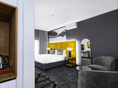 a hotel room with a bed and a chair at Panorama Villa in Graskop