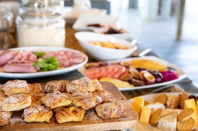 a table topped with plates of different types of food at Simbavati Hilltop Lodge in Timbavati Game Reserve