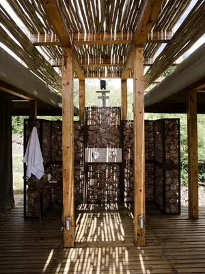 a wooden pergola with a table on a deck at Simbavati Hilltop Lodge in Timbavati Game Reserve