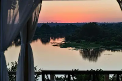 a view of a lake at sunset from a tent at Simbavati Hilltop Lodge in Timbavati Game Reserve