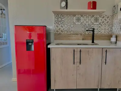 a red refrigerator in a kitchen with a sink at The Acorn @ Skyfall Country Estate in Polokwane