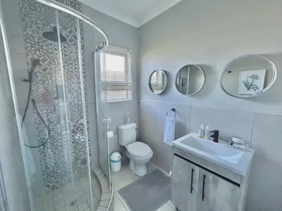a bathroom with a shower and a toilet and a sink at The Acorn @ Skyfall Country Estate in Polokwane