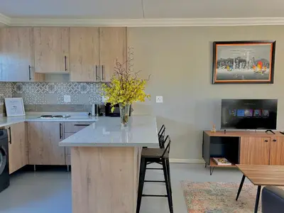 a kitchen with a island with a vase of flowers on it at The Acorn @ Skyfall Country Estate in Polokwane