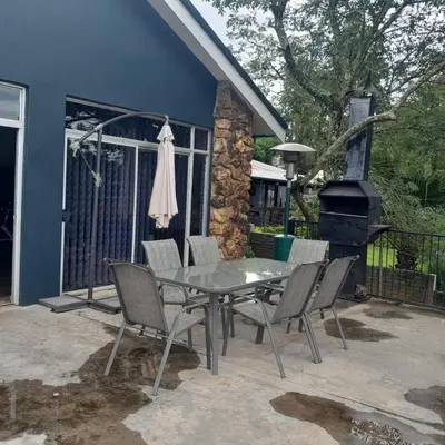 a patio with a table and chairs and a grill at 38 On Andrew Street in Sabie