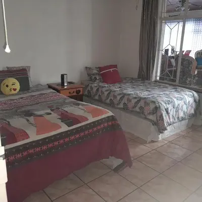 a bedroom with two beds and a window at 38 On Andrew Street in Sabie