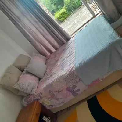a small bed in a room with a window at 38 On Andrew Street in Sabie