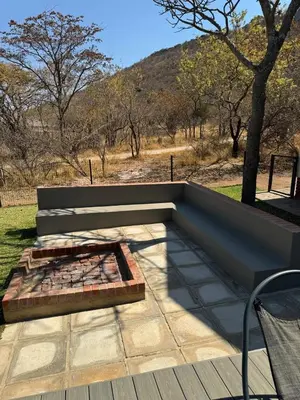 a bench on a patio with a view of a mountain at De Marea villa in Naboomspruit