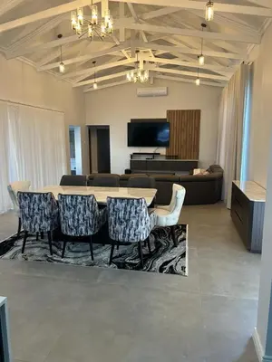 a living room with a table and chairs and a couch at De Marea villa in Naboomspruit