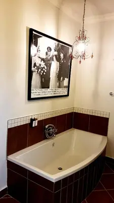 a large tub in a bathroom with a picture on the wall at Barnstormers Rest in Malelane