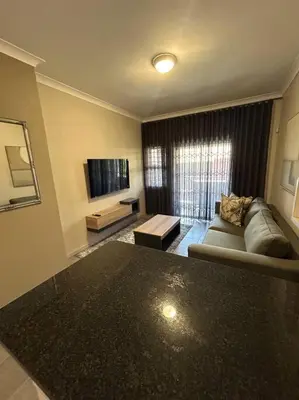 a living room with a couch and a tv at Home away from Home in Pretoria