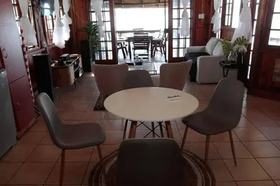 a room with a table and chairs and a living room at Stunning chalet with a dam view. in Vendaland