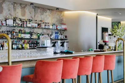 a bar with a row of red chairs in a restaurant at Thango Res in Johannesburg