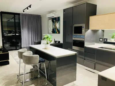 a kitchen with black cabinets and a white counter top at Thango Res in Johannesburg
