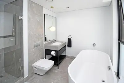 a white bathroom with a toilet and a sink at Thango Res in Johannesburg
