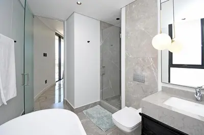 a bathroom with a shower and a toilet and a sink at Thango Res in Johannesburg