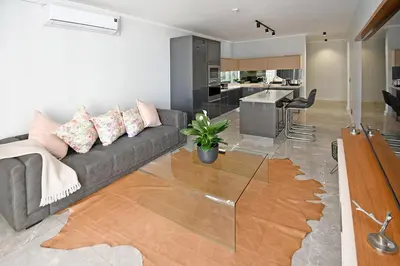a living room with a couch and a kitchen at Thango Res in Johannesburg