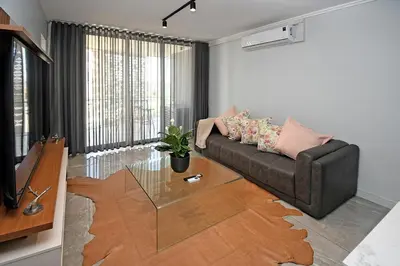 a living room with a couch and a glass table at Thango Res in Johannesburg