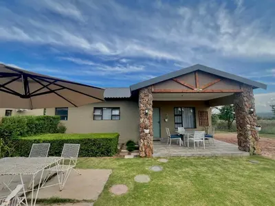 a house with a patio with chairs and a table at The Comfy Corner @ Skyfall Country Estate in Polokwane