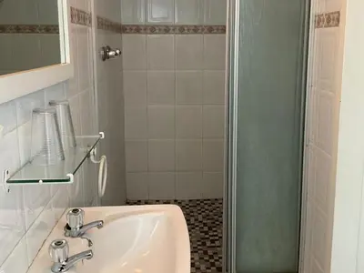 a bathroom with a sink and a shower at Jopasso Guest House in Pretoria