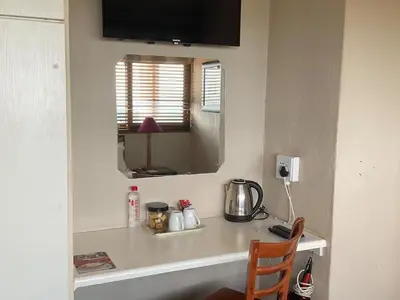 a counter in a room with a table and a mirror at Jopasso Guest House in Pretoria