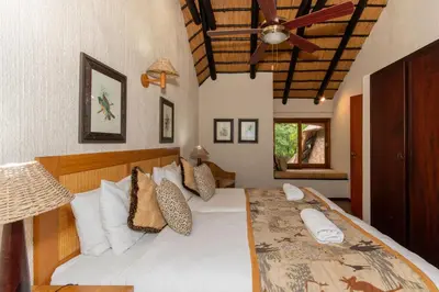 a bedroom with a large white bed with a ceiling at Kruger Park Lodge Unit No. 216 in Hazyview