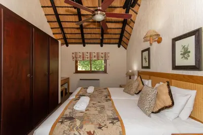 a bedroom with a bed with a ceiling fan at Kruger Park Lodge Unit No. 216 in Hazyview