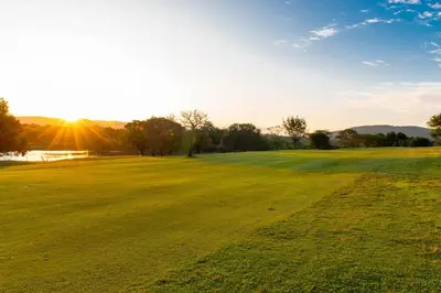 a field of green grass with the sun in the background at Kruger Park Lodge Unit No. 216 in Hazyview