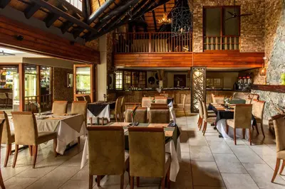 a restaurant with tables and chairs in a room at Kruger Park Lodge Unit No. 216 in Hazyview