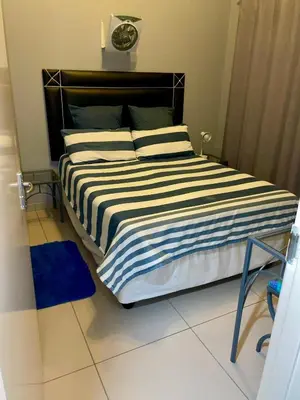a bedroom with a bed with a clock on the wall at Pendleberry Grove Unit 51 in Bela-Bela