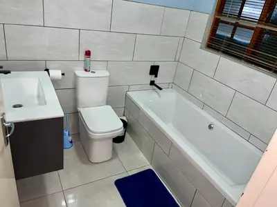 a bathroom with a toilet and a tub and a sink at Pendleberry Grove Unit 51 in Bela-Bela