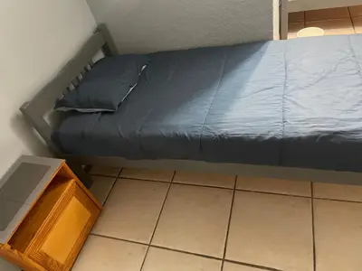 a bed with a blue pillow and a wooden cabinet at Pendleberry Grove Unit 51 in Bela-Bela