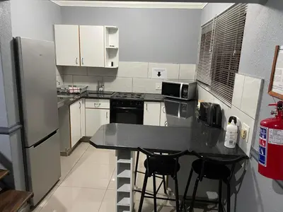 a kitchen with a black counter top and a refrigerator at Pendleberry Grove Unit 51 in Bela-Bela