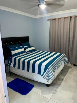 a bedroom with a bed with blue and white stripes at Pendleberry Grove Unit 51 in Bela-Bela