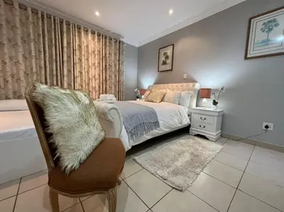 a bedroom with a bed and a chair and a window at 337 Justice Mahomed Guest House in Pretoria