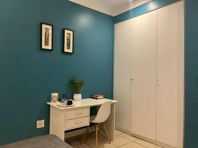 a bedroom with a desk and a blue wall at 337 Justice Mahomed Guest House in Pretoria