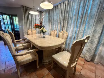 a dining room table and chairs with a vase of flowers at 337 Justice Mahomed Guest House in Pretoria