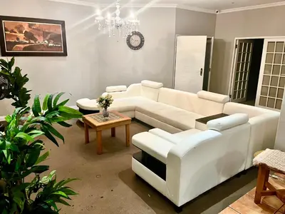 a living room with a white couch and a table at 337 Justice Mahomed Guest House in Pretoria