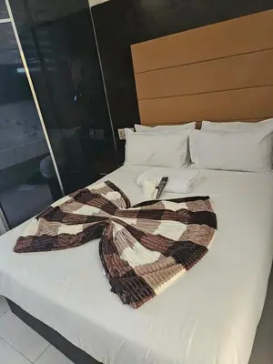 a large white bed with a scarf on it at DBright Lodge in Pretoria