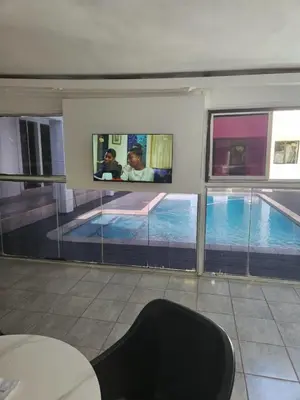 a room with a swimming pool and two televisions at DBright Lodge in Pretoria