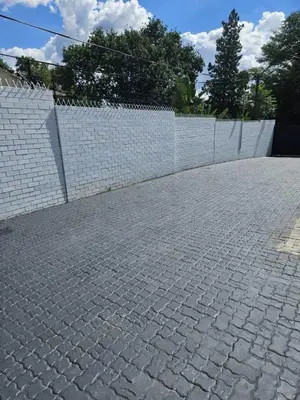 a brick sidewalk next to a white fence at DBright Lodge in Pretoria