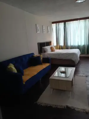 a living room with a couch and a bed at Comfy spacious apartment in Pretoria