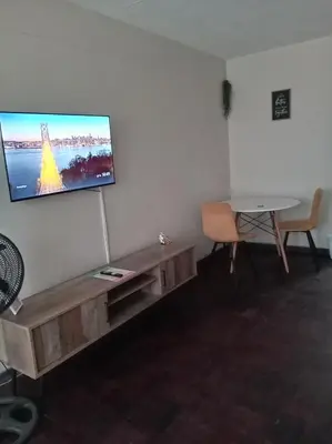 a living room with a flat screen tv on a wall at Comfy spacious apartment in Pretoria