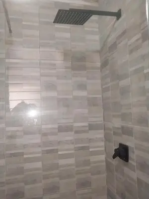 a bathroom with a shower with a black shower head at Comfy spacious apartment in Pretoria