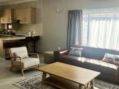 a living room with a couch and a table at Vaendzi Lodge in Nelspruit