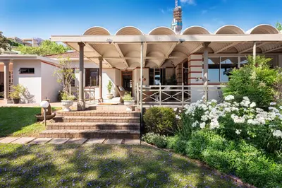 a house with a porch and stairs in a yard at House Falcon in Pretoria