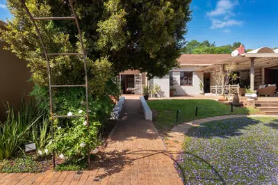 a garden with a ladder next to a house at House Falcon in Pretoria