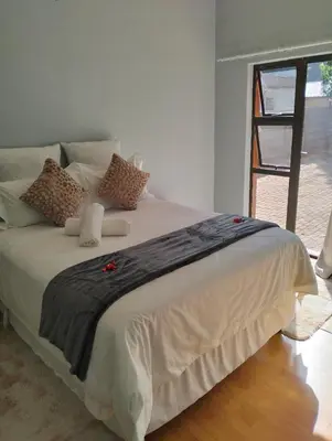 a bedroom with a large white bed with pillows at O&S BnB in Centurion