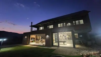 a large house with a lot of windows at night at Bluebell House@799 in Dullstroom