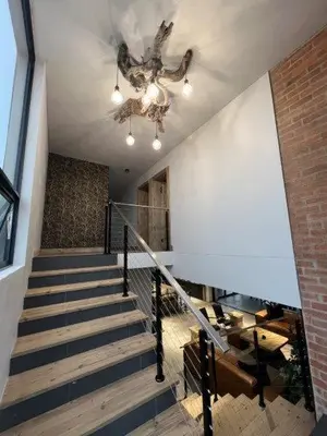 a staircase with a chandelier and a brick wall at Bluebell House@799 in Dullstroom