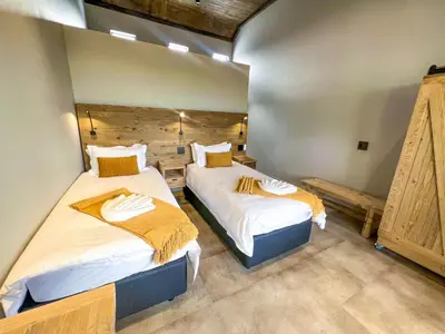 a bedroom with two beds and a wall at Bluebell House@799 in Dullstroom